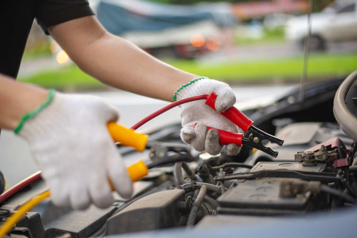 jump cables connecting to car battery to jumpstart car